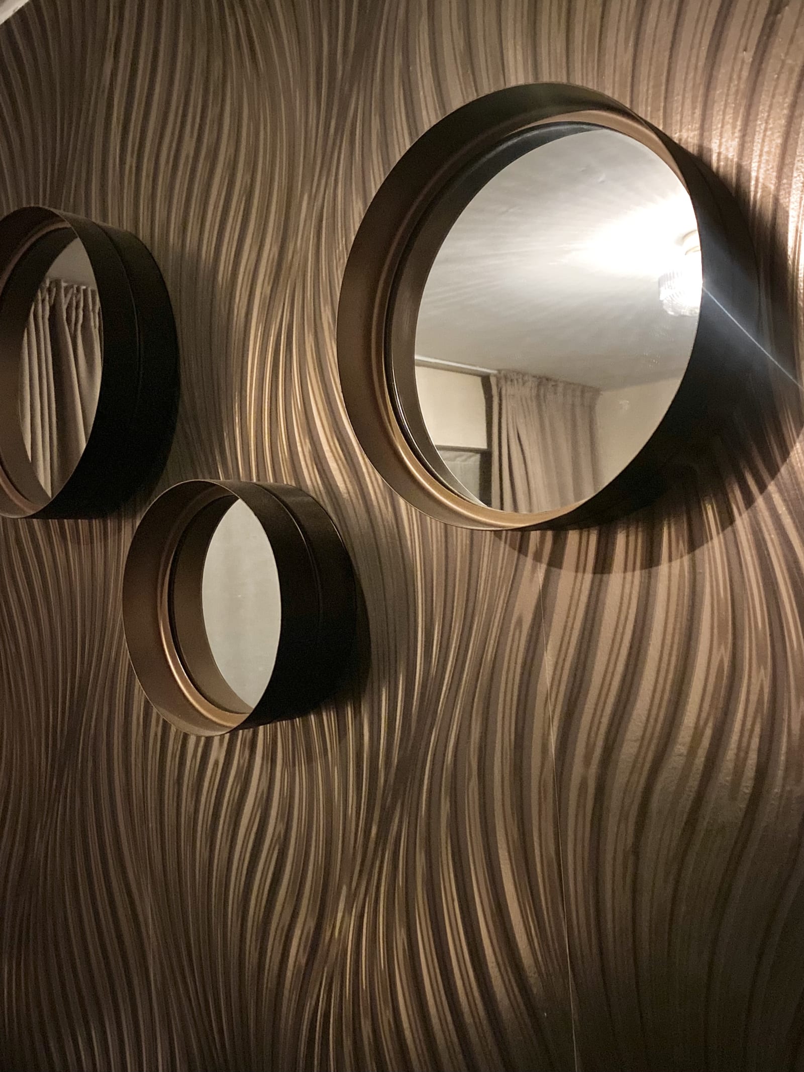 De bronzen golfwand in de studio met drie ronde spiegels